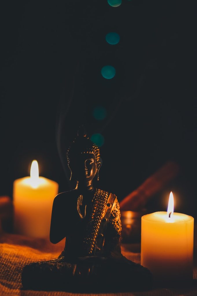 sitting buddha beside pillar candles